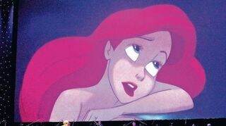 <p>Arielle, die Meerjungfrau, auf großer Leinwand, davor das Orchester und eine der Solistinnen.</p>