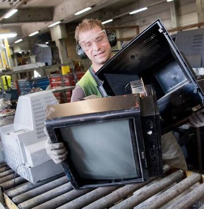 Ein Mitarbeiter einer Deponie sortiert alte Elektrogeräte.