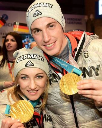 15.02.2018, Südkorea, Pyeongchang, Olympia, Eiskunstlauf, Deutsches Haus. Die Olympiasieger Aljona Savchenko und Bruno Massot zeigen ihre Goldmedaille bei einem Besuch im Deutschen Haus. (zu dpa "Eis-Paar Savchenko/Massot wird nach Klasse-Kür noch Olympiasieger" am 15.02.2018) Foto: Hauke-Christian Dittrich/picture alliance/dpa +++ dpa-Bildfunk +++