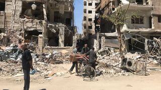 Menschen stehen vor den zerstörten Gebäuden in Duma – dem Ort, in dem es einen Giftgasangriff gegeben haben soll.