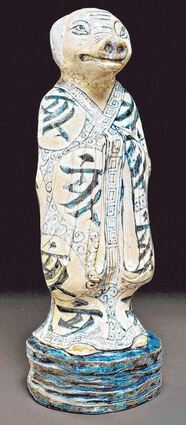 Eine Porzellanplastik aus dem China des 19. Jahrhunderts zeigt eine Beamtenfigur mit Schweinekopf.