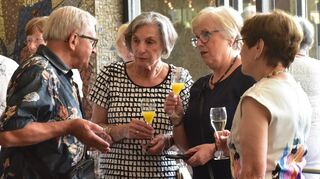 Diskussionen im Foyer des Nationaltheaters: Viele Gäste unterhalten sich im Anschluss noch bei einem Glas Sekt oder Orangensaft angeregt über den Vortrag.