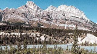 Das Wasser des Saskatchewan Flusses im Norden von Alberta in Kanada leuchtet türkisblau. Der Fluss schlängelt sich an den Rocky Mountains vorbei.