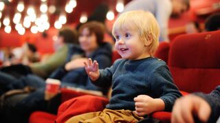 Ein kleiner Junge sieht einen Cartoon im Kino. Für viele Kinder ist das Kino ein mystischer Ort, bei dem das Außergewöhnliche zu sehen ist.