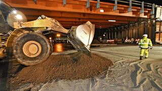Riesige Radlader schütteten ein breites Sandbett unterhalb der alten Brücke auf den Fahrbahnen der A 5 auf. Das bis zu einem Meter hoch aufgetürmte Material dämpfte den Sturz der schweren Stahlbetonbrocken, so dass der Asphalt der Autobahn keinen Schaden nahm.