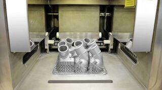 Daimler setzt das 3D-Druckverfahren auch in der Lkw-Sparte ein. Das Bild zeigt den Innenraum eines Druckers mit Ersatzteilen aus Metall.