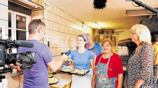 <p>In Röders Backstube: Reporter Ekkehard Drewis vom Hessischen Rundfunk beim Interview mit Eileen (links) und Rita Röder. Im Hintergrund sind Paul und Thomas Röder in der kleinen Backstube beschäftigt. Während Eileen Röder frisch in die Kamera strahlt, kommen Kamerateam und Ortsvorsteherin Renate Netzer (rechts) ordentlich ins Schwitzen.</p>