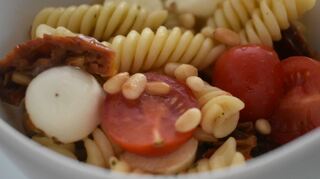 Mit Nudelsalat kann man nichts falsch machen – sollte also auf keinen Fall fehlen. Getrocknete Tomaten und Pinienkerne geben ihm einen mediterranen Touch.