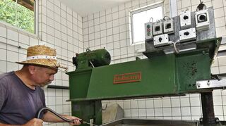 Reinhard Bitsch an der Packpresse in seiner Kelterei.