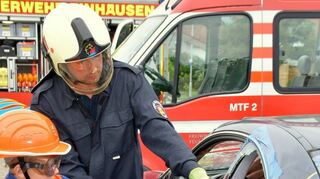 Früh übt sich: Erfahrene Einsatzkräfte zeigen dem Nachwuchs den Umgang mit der Rettungsschere.