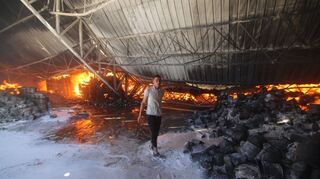 In Rafah im südlichen Gazastreifen inspiziert ein Palästinenser ein Lagerhaus, das bei einem israelischen Luftangriff getroffen wurde.