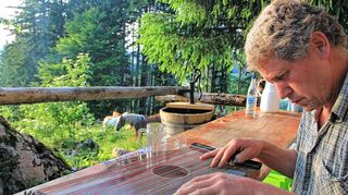 <p>Kaspar Brandhofer empfängt die Teilnehmer des historischen Almritts in Oberbayern mit Zitherklängen, während die kräftigen Farben der herbstlichen Wiesen und Wälder die Sinne beruhigen und in der Ferne sich die Alpenkette durch die Wolken schiebt.</p>