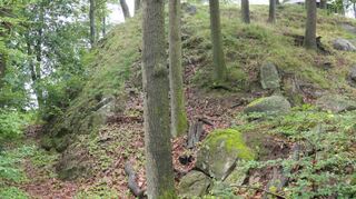 Auf der Nordseite der ehemaligen Burg am Lindenfelser Köpfchen ließen die Erbauer einen noch heute gut erkennbaren Graben zum Schutz vor Eindringlingen aus dem Granit hauen (linke Bildseite).