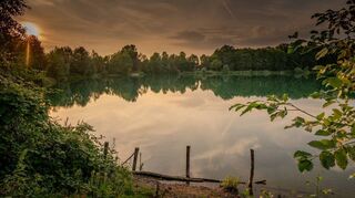 Still ruht der See in den Abendstunden: Die Erlache ist Naturparadies und Refugium zugleich. Probleme gibt es allerdings nach wie vor mit der Vermüllung des Uferbereichs und des Gewässers sowie mit Besuchern, die das Badeverbot missachten.