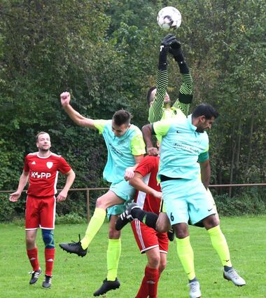 Beim Abfangen eines Flankenballs wird SVW-Torwart Johannes Daum von den Rodauern Raphael Brighina und Salman Ahmad (re.) angesprungen.
