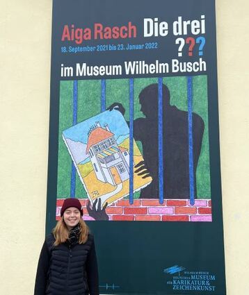 BAnane-Redakteurin Cara vor der Illustration eines drei ???-Covers.