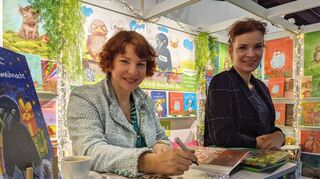 Die „Bilderbuchschwestern“ Lee D. Böhm (links, Illustration) und Andrea Böhm (rechts, Text) bei der Signierstunde an ihrem Stand auf der Frankfurter Buchmesse, wo sie ihr neues Werk „Die Rabenweihnacht“ präsentierten.