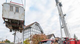 Da schwebt er: Der alte Zirkuswagen von Walter Renneisen wurde aus dem Garten des Schauspielers auf die Straße gehoben.