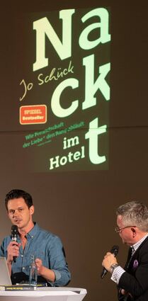 ZDF-Moderator Jo Schück (l.) stellte in Lorsch sein erstes Buch „Nackt im Hotel“ vor. Organisiert hatte die Lesung Hans-Jürgen Brunnengräber (r.), der den gut besuchten Abend im Paul-Schnitzer-Saal auch unterhaltsam moderierte.