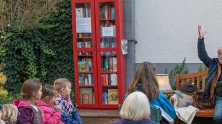 Das feuerrote Bücherregal am Mehrgenerationenhaus gibt es seit zehn Jahren. Das Jubiläum wurde mit der Einweihung einer Lesebank samt Lesung von Berthold Mäurer gefeiert.