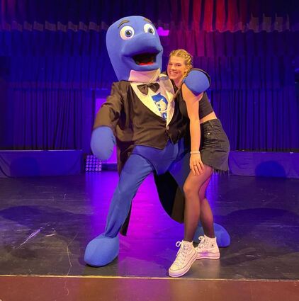 Das Bild zeigt Tamina mit dem Clubmaskotchen Floss.