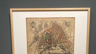 Eine Karte von Amsterdam sowie Porträts sind in der Ausstellung zu sehen.
