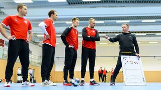 Bundestrainer Alfred Gislason (rechts) steht an der Taktiktafel und spricht zu seinen Spielern Lukas Mertens (v.l.), Kai Häfner, Luca Witzke und Julius Kühn.