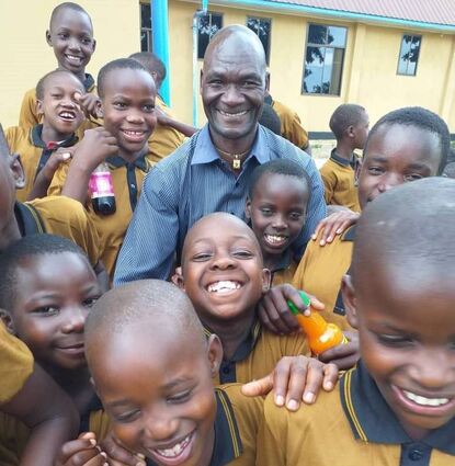 Schüler des Ibondo Education Center in Tansania mit gespendeter Kleidung und Lebensmitteln.