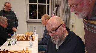 Vorsitzender Michael Gehlhar (sitzend v.) und Albert Grieser (r.) blicken in die einst von Franz Gärtner angelegten Chroniken des Schachklubs 47 Einhausen, der seit 75 Jahren besteht.