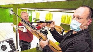 Vorsitzender Sigurd Stephan (l.) und der Sportliche Leiter Thorsten Forell zeigen einige der Luftdruckwaffen des Vereins. Vorne im Bild ist ein heute im Schießsport nicht mehr gebräuchlicher Seitenspanner zu sehen.