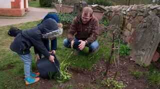 Pfarrer Lukas von Nordheim erklärt den Kindern der Reporterin, wie das mitgebrachte Wasser richtig verwendet wird.