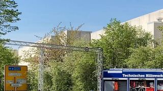 Die Traverse über der L 3111 steht. Die Stromleitung darüber soll die Dusch-Container gegenüber versorgen.