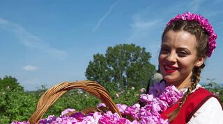 Sag’s durch die Blume: Eine junge Bulgarin in traditioneller Tracht zeigt ihre „Ernte“.