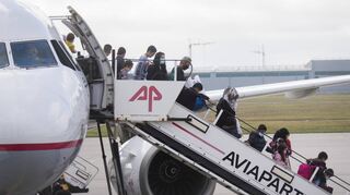 Migranten aus dem griechischen Lager Moria auf der Insel Lesbos steigen aus einem Flugzeug am Flughafen Hannover.