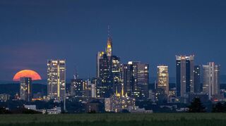 Der Vollmond geht auf über der Frankfurter Bankenskyline.