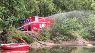 Der Abrollbehälter der Lorscher Feuerwehr pumpt bis zu 4000 Liter Wasser pro Minute aus einem Baggersee nahe der Brandstelle bei Münster.