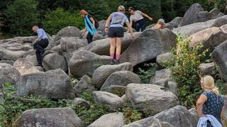 Zum Abschluss seines Besuchs am Felsenmeer wagte sich Staatssekretär Uwe Becker (links) auf die Felsen.