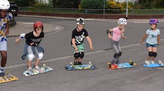 Im Ansatz zum Sprung sind die Kinder der Ferienbetreuung, die zusammen mit ihrem Betreuer Jean-Luc Bakonalim die Skateboards auf die Rollen drehen wollen.