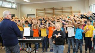 Zusammen sind wir stark: 200 Kinder der Nibelungenschule mit Solistin Alexandra (vorne) unter Leitung von Klaus Vorschütz eröffneten die Feierstunde zur Übergabe des Schulgartens und zum Abschluss der Sanierung.