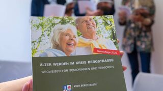 Die aktuelle Ausgabe des „Wegweisers für Seniorinnen und Senioren – Älter werden im Kreis Bergstraße“ wurde jetzt vorgestellt. Im Hintergrund (v.l.) blättern Martina Zwecker (Fachstelle Leben im Alter), Landrat Christian Engelhardt und Susanne Hagen (Vorsitzende des Kreisseniorenbeirats) in dem 115 Seiten dicken Büchlein.