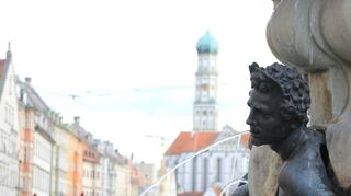 Wasser ist das bestimmende Element in Augsburg und überall gegenwärtig, wie am Brunnen auf dem Markt.