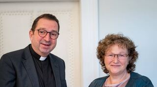 Das Bild zeigt Pfarrer Michael Bartmann und Pfarrerin Roswitha Grieser mit einer Figur von St. Martin, dem Mainzer Bistumspatron.