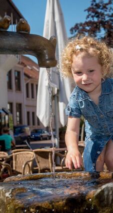 Aus dem Lorscher Tabakbrunnen fließt Trinkwasser. Gerade für Kinder ist das eine willkommene Abkühlung im Sommer.