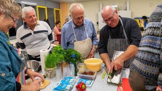 Von Guy Bastian (r.) ließen sich die Vereinsmitglieder zeigen, wie ein köstliches französisches Menü entsteht. In der Küche der Siemens-Schule wurde gemeinsam Boef Bourguignon zubereitet. Eine passende Vorspeise sowie ein Dessert entstanden unter Anleitung des erfahrenen Kochs ebenso. Zum Schluss wurde getafelt.
