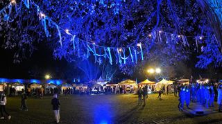 Unter beleuchteten Bäumen und direkt vor der blau angestrahlten Klostermauer wird zum zweiten Mal der Weihnachtsmarkt auf der Klosterwiese gefeiert.