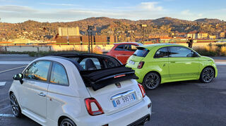 mid Turin - Cabrio-Vorgängermodell und neueste Limousine über den Dächern von Turin.