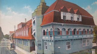 Die Postkarte zeigt den Zustand des Hotels Krone im Jahr 1907: Ein wuchtiger Turm verbindet Nord- und Südgebäude. Die Loggia im ersten Geschoss sollte den Gästen den damals attraktiven Blick auf die Bachgasse und die Berge ermöglichen.