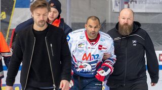Physiotherapeut Michael Ludwig (rechts) begleitet den sichtlich benommenen Adler-Stürmer Nigel Dawes vom Eis.