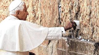 2009: Benedikt XVI. steckt einen Zettel mit persönlichen Anliegen in die Ritzen der Jerusalemer Klagemauer.