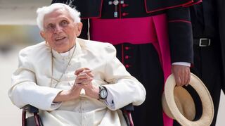 2020: Der emeritierte Papst Benedikt XVI. im Rollstuhl am Flughafen München in Freising vor dem Abflug nach Rom.